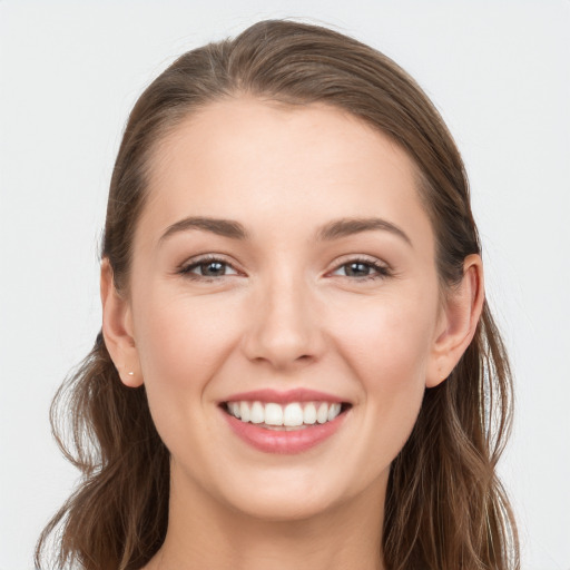 Joyful white young-adult female with long  brown hair and grey eyes