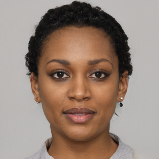 Joyful black young-adult female with short  black hair and brown eyes