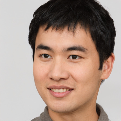 Joyful asian young-adult male with short  black hair and brown eyes