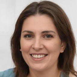 Joyful white adult female with long  brown hair and brown eyes