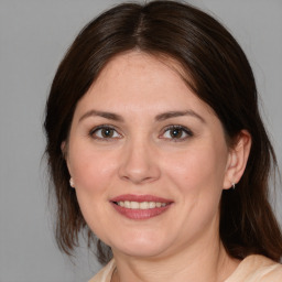 Joyful white adult female with medium  brown hair and brown eyes