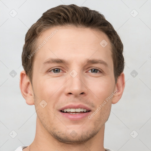 Joyful white young-adult male with short  brown hair and grey eyes