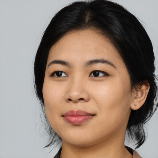 Joyful asian young-adult female with medium  black hair and brown eyes