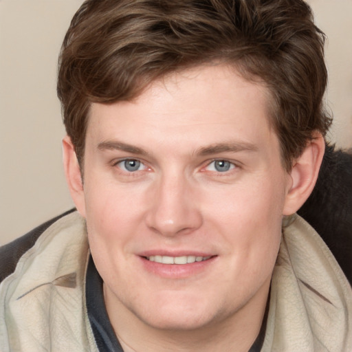 Joyful white young-adult male with medium  brown hair and blue eyes