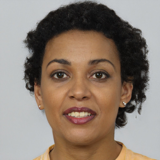 Joyful black young-adult female with short  brown hair and brown eyes