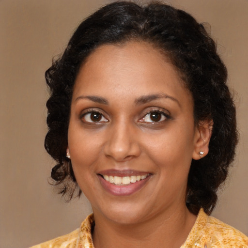 Joyful black young-adult female with medium  brown hair and brown eyes
