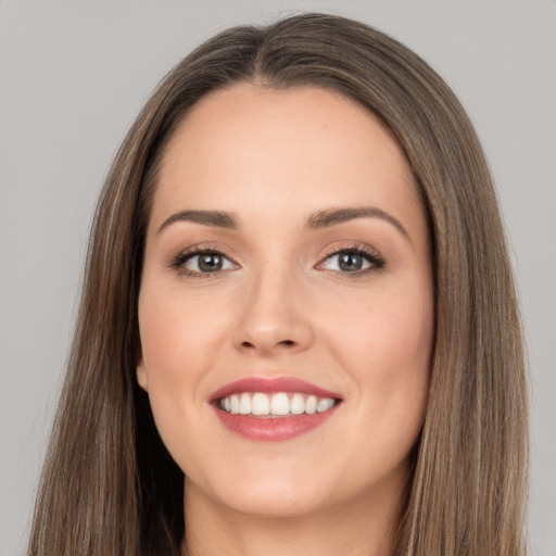 Joyful white young-adult female with long  brown hair and brown eyes