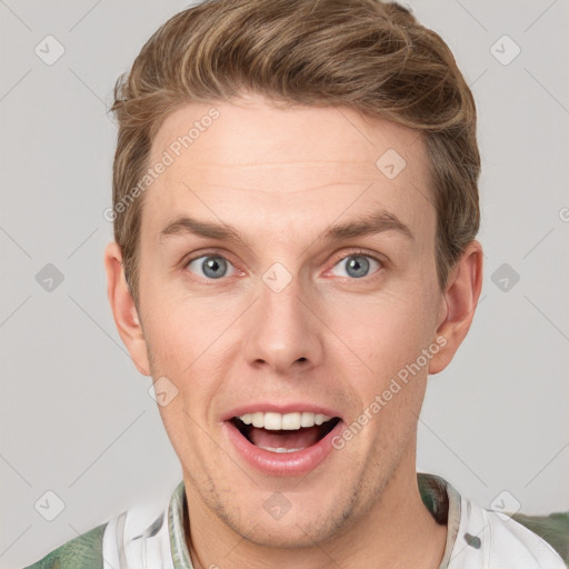 Joyful white young-adult male with short  brown hair and grey eyes