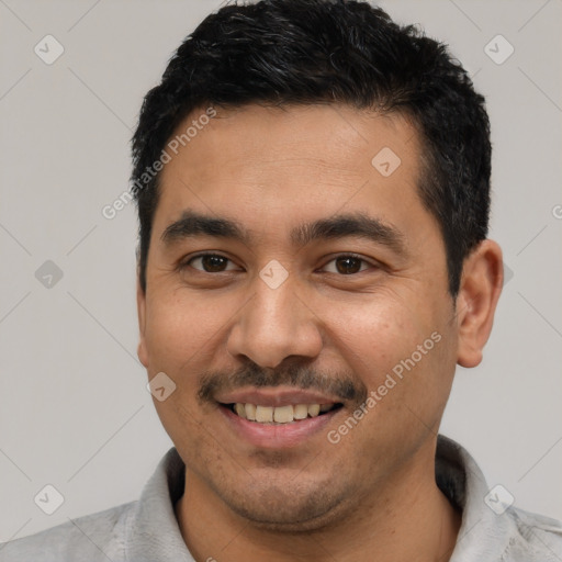 Joyful latino young-adult male with short  black hair and brown eyes