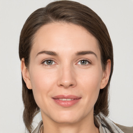 Joyful white young-adult female with medium  brown hair and grey eyes