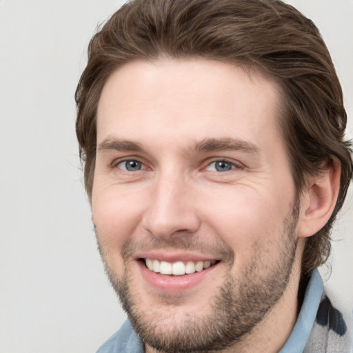 Joyful white young-adult male with short  brown hair and grey eyes