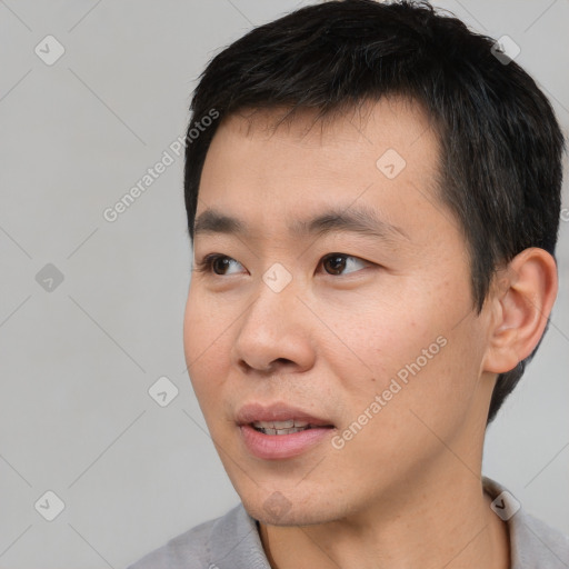 Joyful asian young-adult male with short  black hair and brown eyes