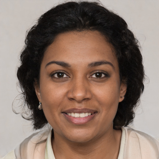 Joyful black young-adult female with medium  brown hair and brown eyes