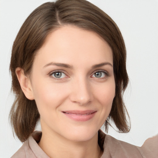 Joyful white young-adult female with medium  brown hair and grey eyes