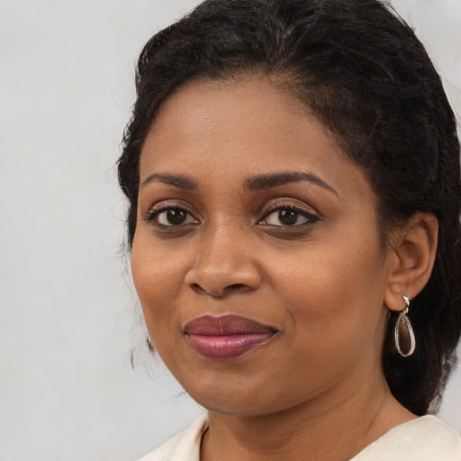 Joyful black young-adult female with medium  brown hair and brown eyes