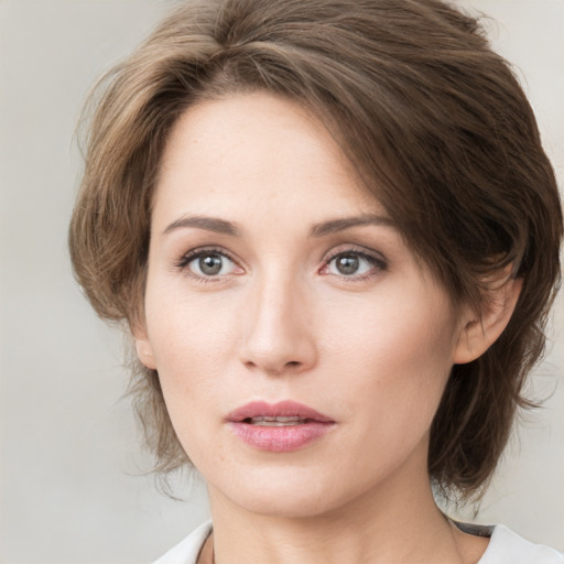 Joyful white young-adult female with medium  brown hair and green eyes