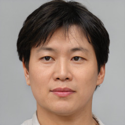 Joyful asian adult male with short  brown hair and brown eyes