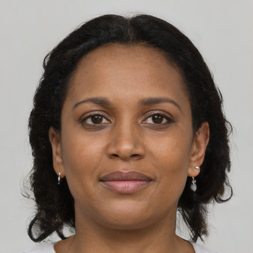 Joyful black young-adult female with medium  brown hair and brown eyes