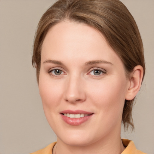 Joyful white young-adult female with medium  brown hair and grey eyes