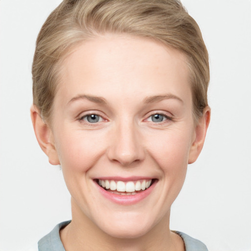 Joyful white young-adult female with short  brown hair and blue eyes