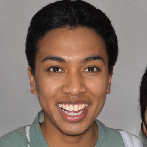 Joyful black young-adult female with short  black hair and brown eyes
