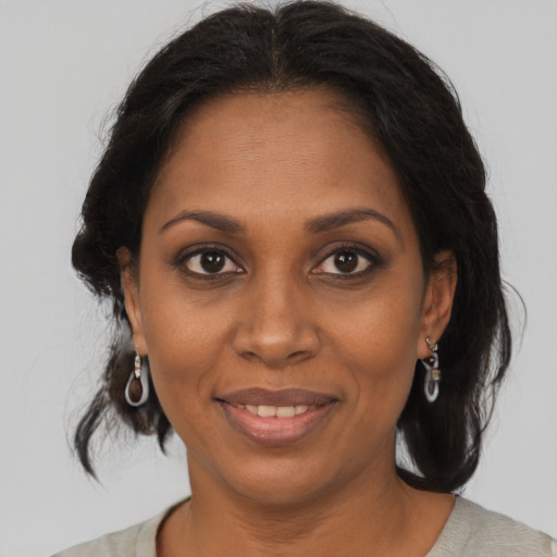 Joyful black adult female with medium  brown hair and brown eyes