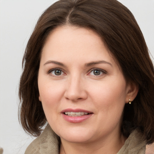 Joyful white young-adult female with medium  brown hair and grey eyes