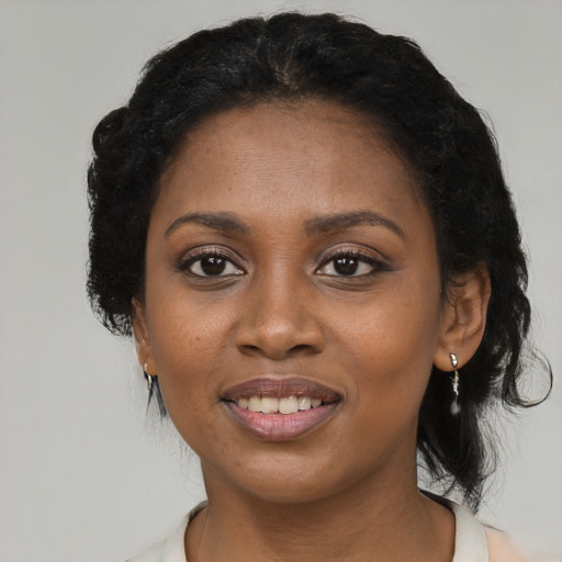 Joyful black young-adult female with medium  black hair and brown eyes