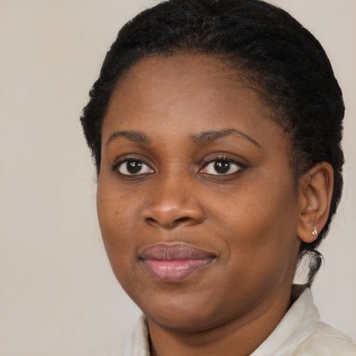 Joyful black young-adult female with short  brown hair and brown eyes