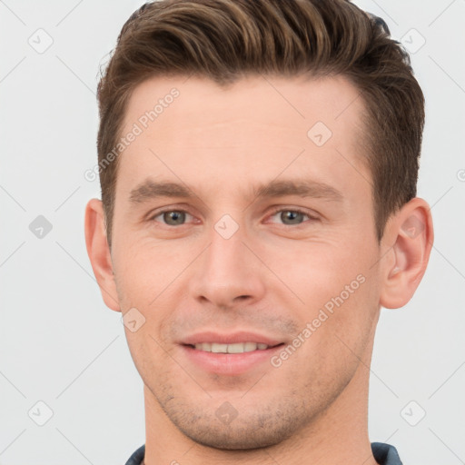 Joyful white young-adult male with short  brown hair and grey eyes