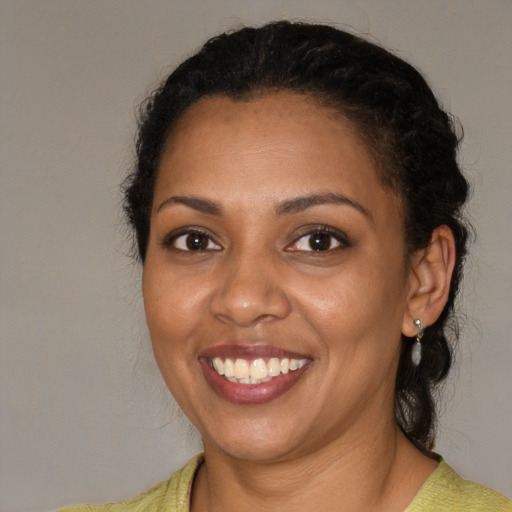 Joyful black young-adult female with medium  brown hair and brown eyes