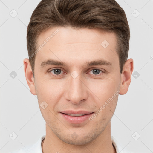 Joyful white young-adult male with short  brown hair and grey eyes