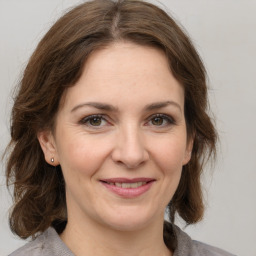 Joyful white adult female with medium  brown hair and brown eyes