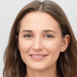 Joyful white young-adult female with long  brown hair and grey eyes