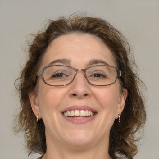 Joyful white adult female with medium  brown hair and green eyes