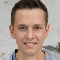 Joyful white young-adult male with short  brown hair and grey eyes