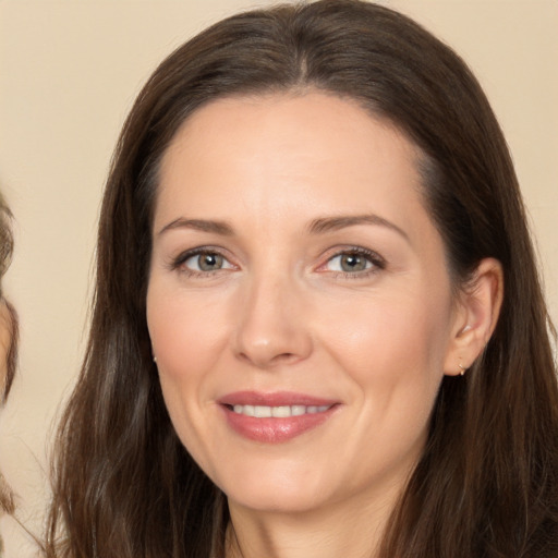 Joyful white adult female with long  brown hair and brown eyes