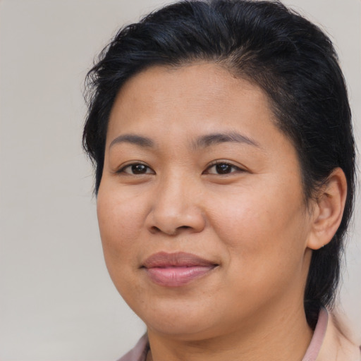 Joyful asian adult female with medium  brown hair and brown eyes