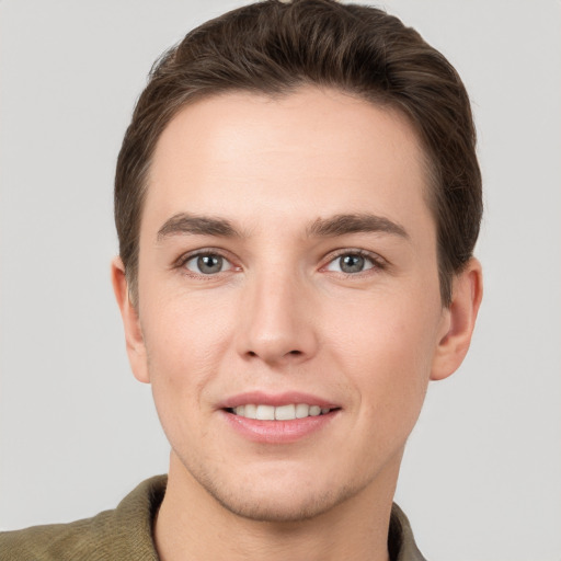 Joyful white young-adult male with short  brown hair and grey eyes