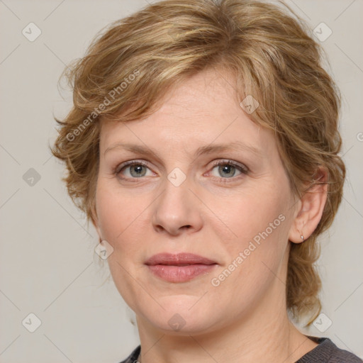 Joyful white adult female with medium  brown hair and blue eyes