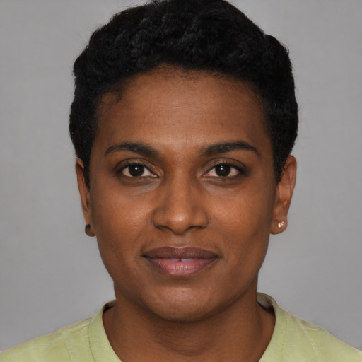 Joyful black young-adult female with short  black hair and brown eyes