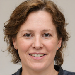 Joyful white adult female with medium  brown hair and grey eyes