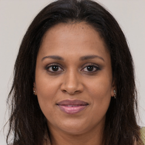 Joyful black young-adult female with long  brown hair and brown eyes