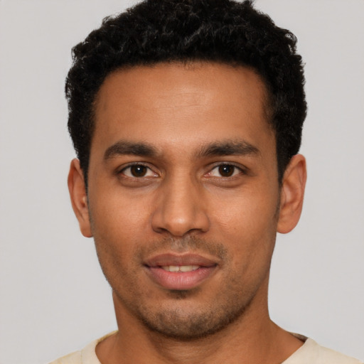 Joyful latino young-adult male with short  black hair and brown eyes