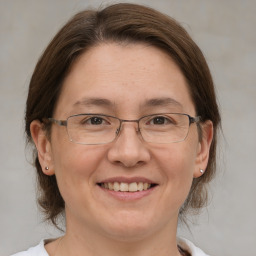 Joyful white adult female with medium  brown hair and grey eyes