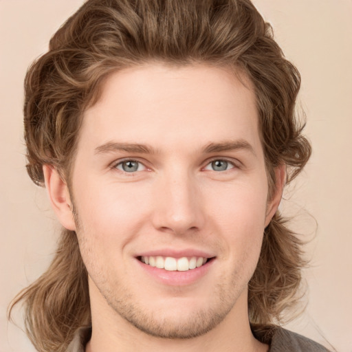 Joyful white young-adult male with medium  brown hair and grey eyes