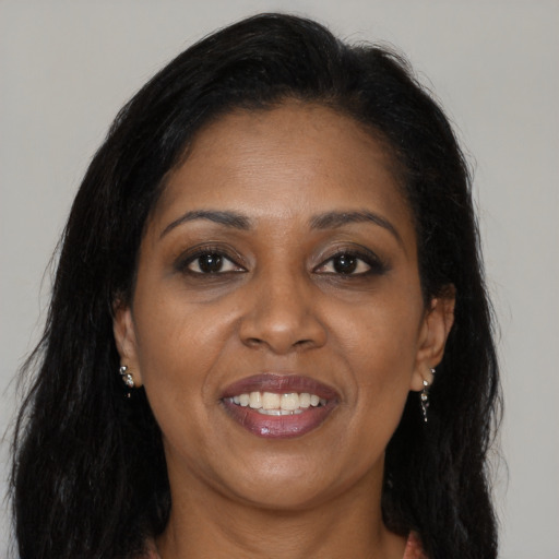 Joyful black adult female with long  brown hair and brown eyes