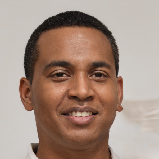 Joyful black young-adult male with short  black hair and brown eyes