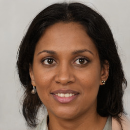 Joyful black adult female with long  brown hair and brown eyes