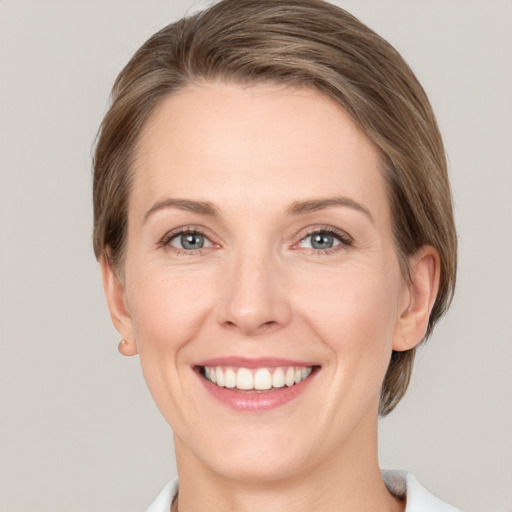 Joyful white young-adult female with medium  brown hair and grey eyes